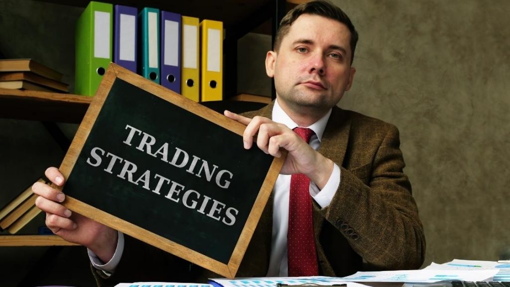 man holding trading strategies sign